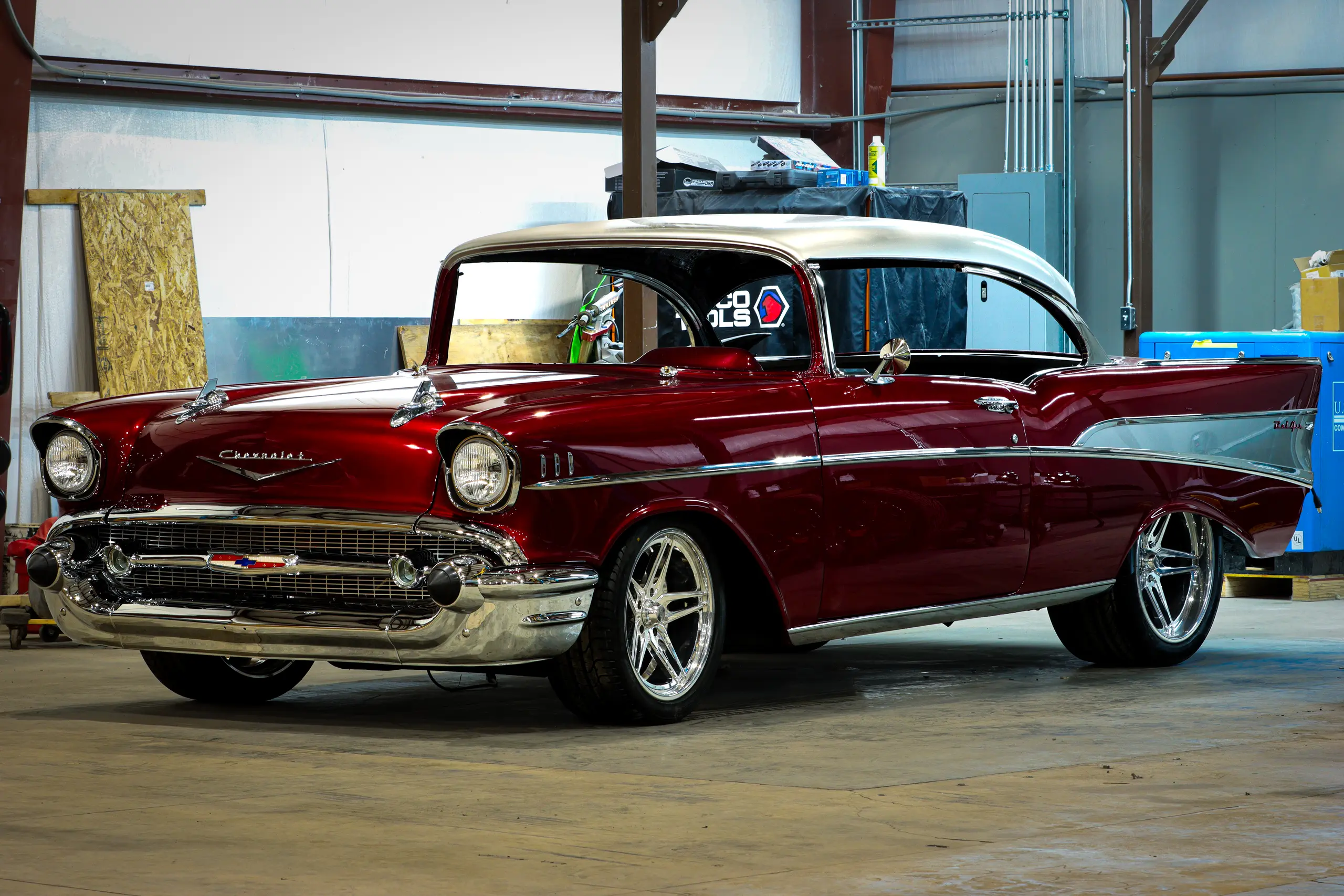 Red 1957 Chevrolet Bel Air in the paint booth with its hood raised